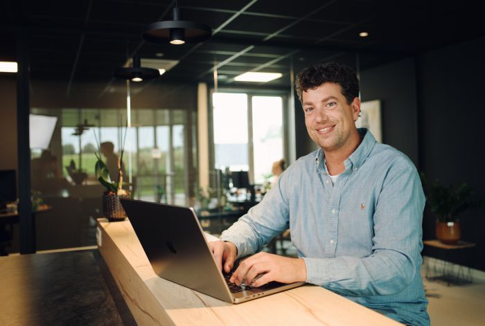 Professional achter een laptop aan een bureau.